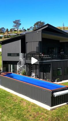 a house with a swimming pool in the middle of it's lawn area, surrounded by grass and trees