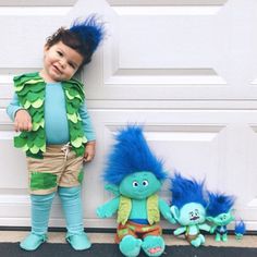 a little boy that is standing next to two stuffed animals in front of a door