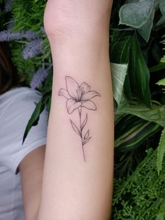 a woman's arm with a flower tattoo on the left side of her arm