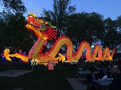 a large dragon statue is lit up at night