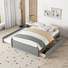 a bed with two drawers underneath it in a room next to a rug and window