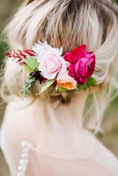 a woman with flowers in her hair wearing a flower headpiece on her wedding day