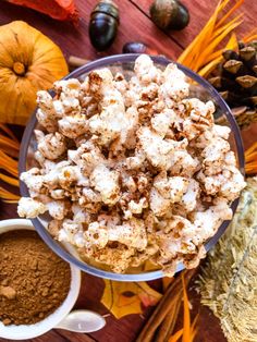 a bowl filled with popcorn surrounded by fall decorations