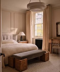 a bedroom with a bed, desk and chair next to a window in the room