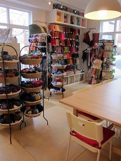 a room filled with lots of different types of shoes and baskets on the wall next to a table