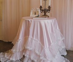 a table topped with a cake and two candelabra candles on top of it