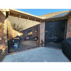 an open garage door in front of a brick building with a grill on the outside