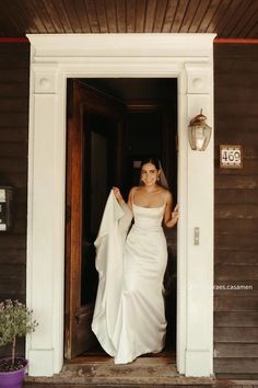 a woman in a wedding dress is standing outside the door