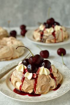 there are two desserts on the plates with cherries