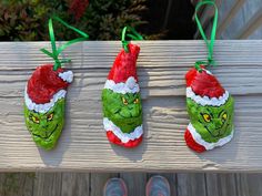 three handmade christmas stockings hanging on a wooden rail with green and red santa hats