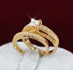 two gold wedding rings on top of a white towel