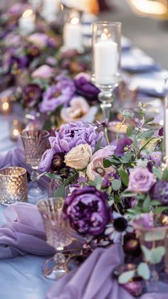 the table is set with purple flowers and candles for an elegant dinner or wedding reception