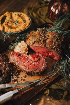 roast beef with rosemary sprigs on a cutting board next to other meats