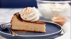 a piece of cake with whipped cream on top is sitting on a plate next to a fork