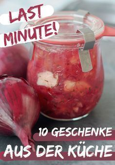 a jar filled with red onions sitting on top of a table