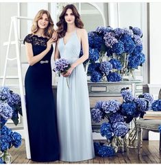 two beautiful women standing next to each other in front of blue flowers and vases