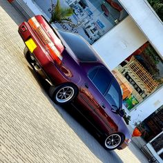 a red car parked in front of a building