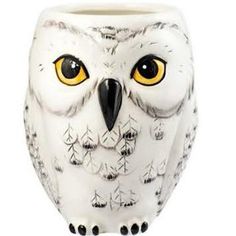 an owl shaped vase with yellow eyes and black tips on it's head is shown