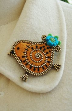 a close up of a brooch on a white shirt with a blue flower in the center