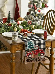 a christmas tree is in the background behind a table with plates and utensils on it