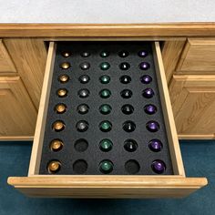 a drawer with several pairs of earrings in it and some drawers on the side that are open