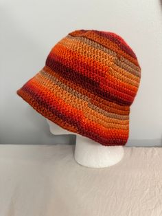 an orange and brown hat on top of a white mannequin head