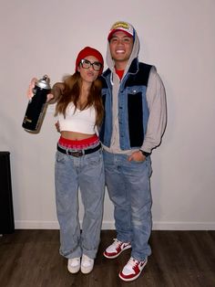 a man and woman dressed up in costumes posing for the camera with one holding a bottle