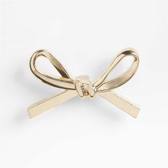 a gold bow brooch on a white background