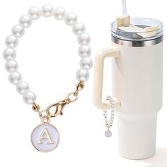 a coffee cup and bracelet with initial charm