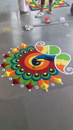 a person standing in front of a colorful rug on the floor with an artistic design