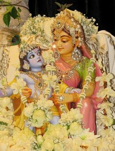 a statue of two women sitting next to each other with flowers in front of them