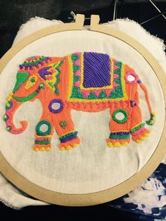 an embroidered elephant is sitting on a pillow