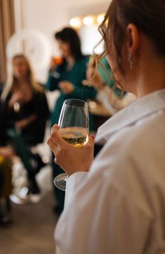 a woman holding a wine glass in her hand