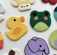 several crocheted animal faces are shown on a white surface with different colors and shapes