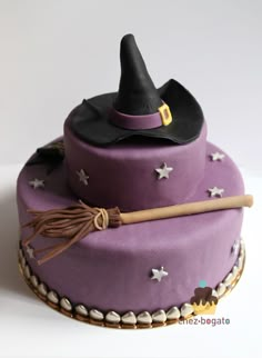 a purple cake with a witch hat and broom on top