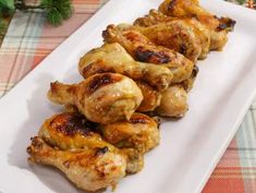 chicken wings on a white plate with pine branches in the backgroung, ready to be eaten