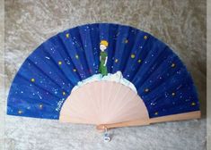 a blue fan with a cartoon character on it sitting on the floor next to a wall