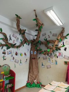 a tree with many pictures on it in the corner of a child's room