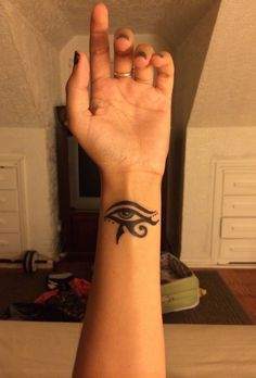 a woman's wrist with an eye tattoo on it