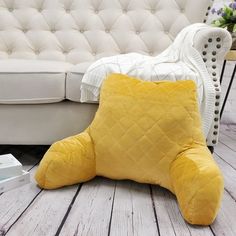 a yellow pillow sitting on top of a wooden floor