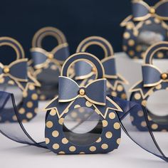 some blue and gold decorated items on a white table with polka dot ribbon around them