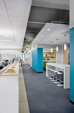 an office with blue and white walls, counter tops and bar stools in the foreground