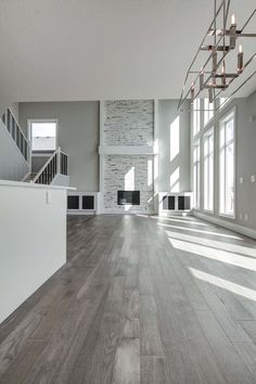 an empty living room with white walls and wood flooring is pictured in this image