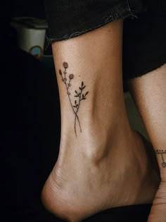 a woman's foot with a small flower tattoo on her left side and an arrow in the middle