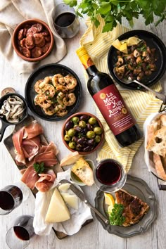 a table topped with plates of food and wine