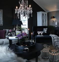 a living room filled with furniture and a chandelier hanging over the top of it