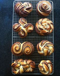 six cinnamon rolls on a cooling rack ready to be baked