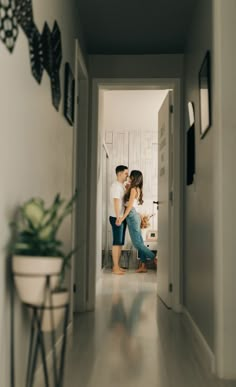 a man and woman are standing in the hallway