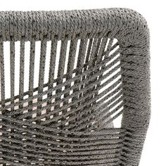 a gray wicker chair sitting on top of a white floor