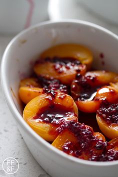 a white bowl filled with sliced peaches on top of a table